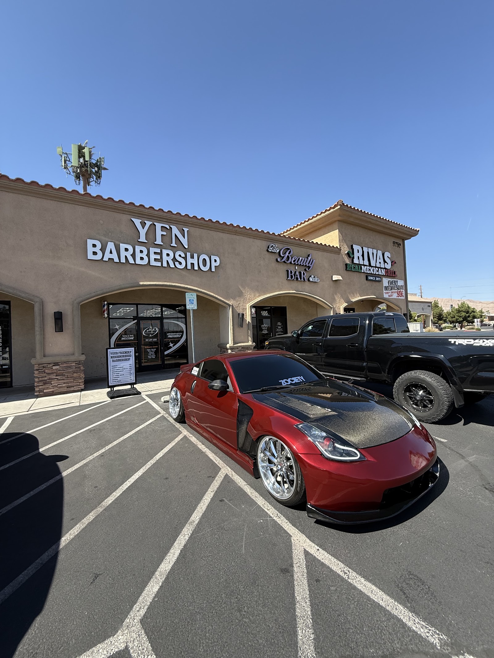 YFN Barbershop storefront in strip mall with red sports car parked in front